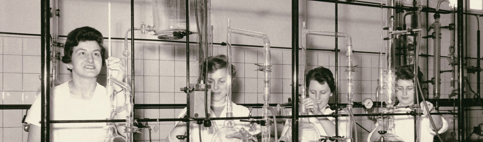 Historische Schwarz-weiß-Aufnahme von vier arbeitenden Frauen in einem Labor 